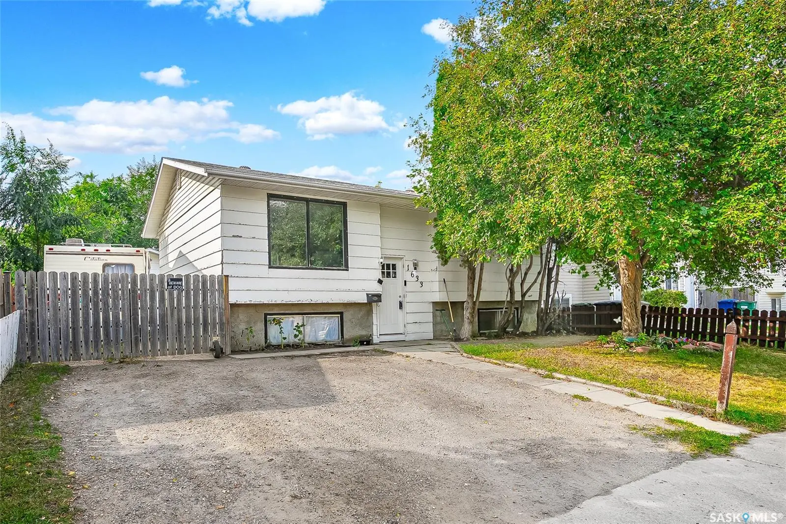 Exterior photo of the property at 1633 B Avenue N, Saskatoon – a charming bi-level home with large garage and backyard